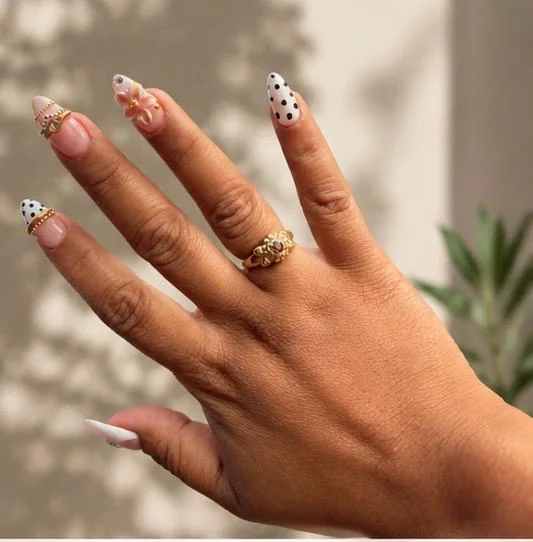 Soft Gel Nail Extensions with white tips, black polka dots, gold bangle-style details, and floral accents.